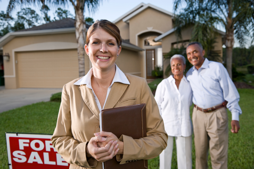 Realtor with African American couple outside house for sale