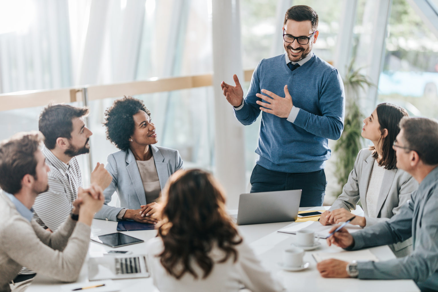  A person in charge is leading a team of people and coordinating with stakeholders in a meeting.