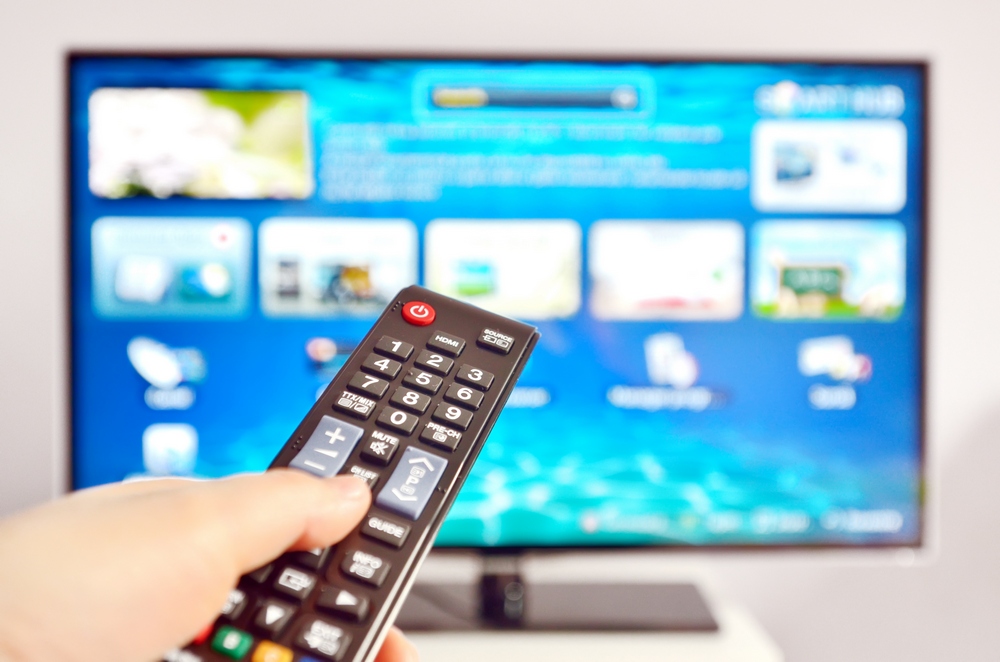 Smart tv and  hand pressing remote control