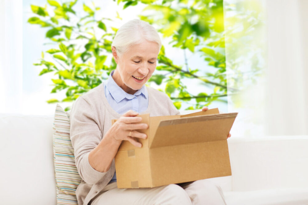 happy senior woman with parcel box at home
