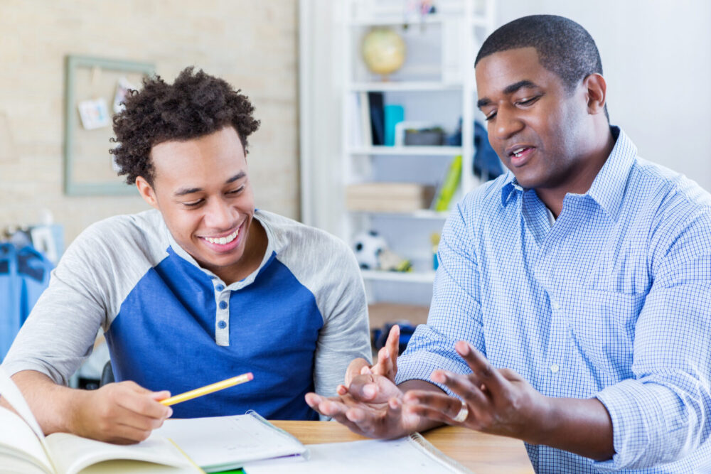 Dad helps teenage son with homework