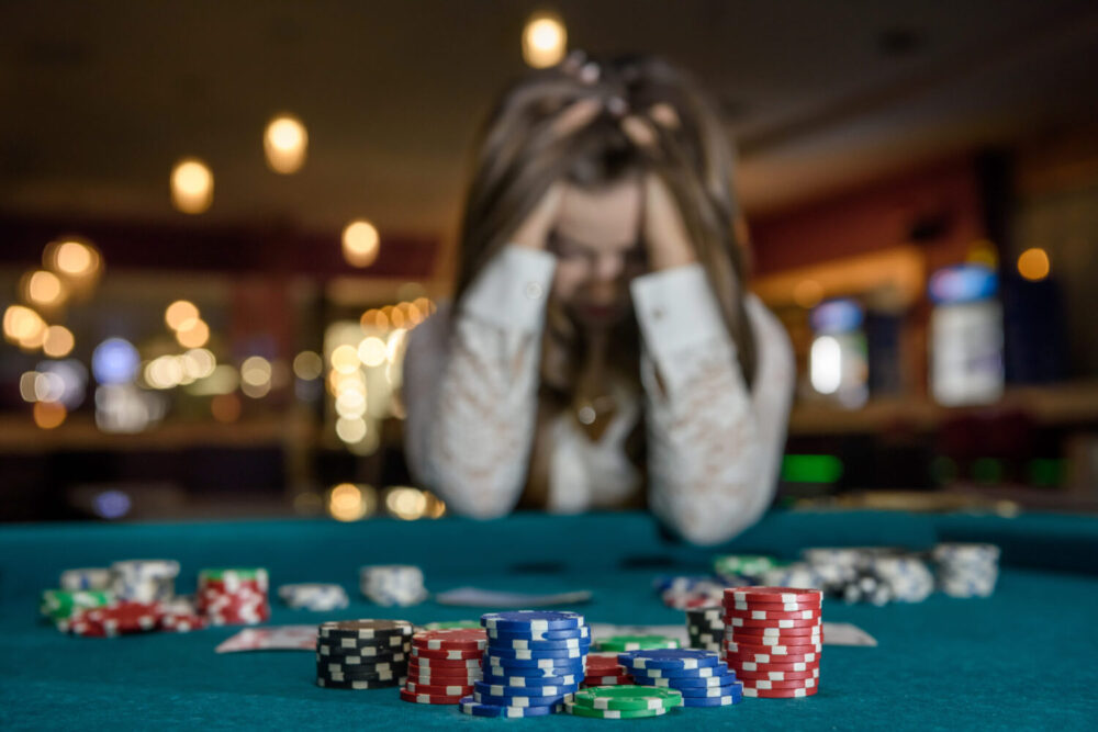 upset-woman-in-casino-sitting-behind-poker-table-stockpack-istock-scaled