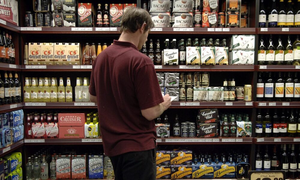 An employee checks the stock of a Dan Murphy’s Liquor Outlet
